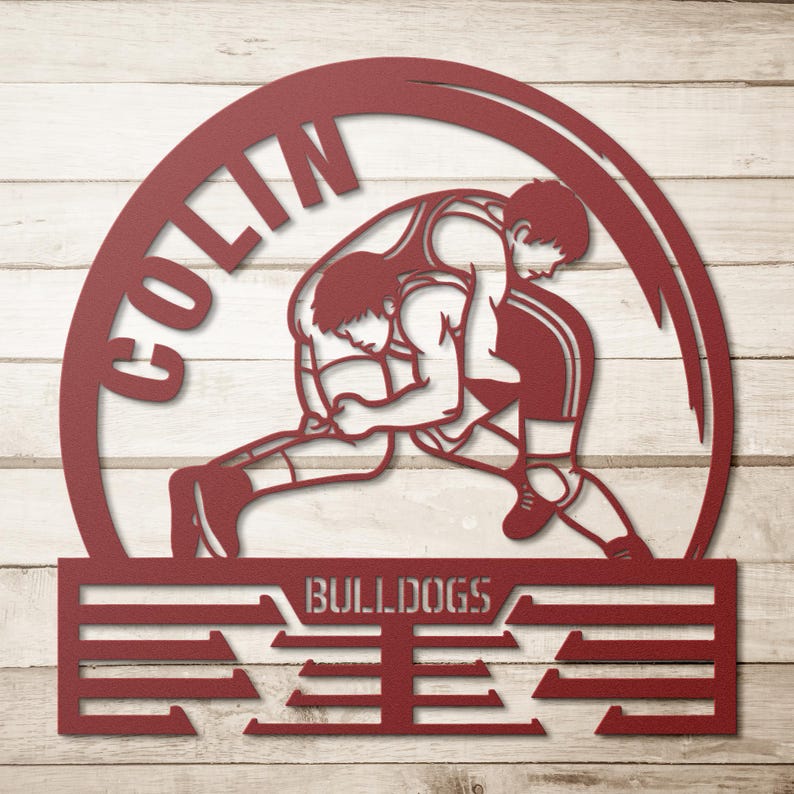 Op de afbeelding: Een rood metalen bord met twee worstelaars in actie, geplaatst in een cirkelvormig frame. De naam "COLIN" staat in een boog bovenaan, met "BULLDOGS" en een gestileerd ontwerp eronder. Ontworpen voor wandmontage.