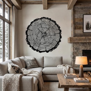 Oversized black tree ring metal art, large rustic mountain house wall decor above cozy living room sofa