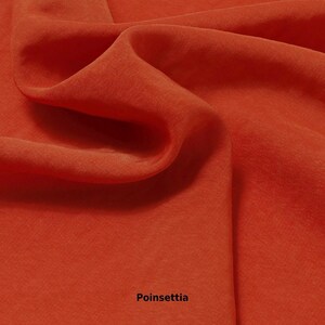 May include: Close-up of a flowing, textured fabric in a vibrant poinsettia red color. The fabric is draped, creating soft folds and shadows. The word "Poinsettia" is printed at the bottom of the image.