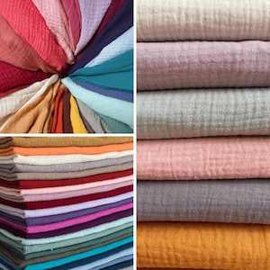 Puede incluir: Un conjunto de 20 muestras de tela de diferentes colores. La tela es un material de gasa suave y texturizado. Los colores incluyen rosa, rojo, naranja, amarillo, verde, azul, morado y gris.
