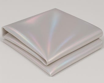 May include: Folded, iridescent fabric in a square shape. The fabric has a pearlescent sheen, with hints of pink, blue, and green. The edges are neatly folded, creating a clean and modern look. The fabric appears to be smooth and soft.