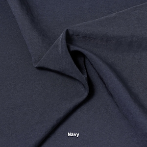 May include: A close-up of navy blue fabric with soft folds and a textured surface. The word "Navy" is printed in white at the bottom of the image. The fabric appears to be a medium weight material.