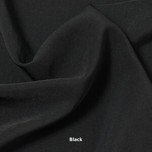 May include: A close-up shot of black fabric with soft folds and a smooth texture. The word "Black" is printed in white at the bottom of the image. The fabric appears to be lightweight and flowing.
