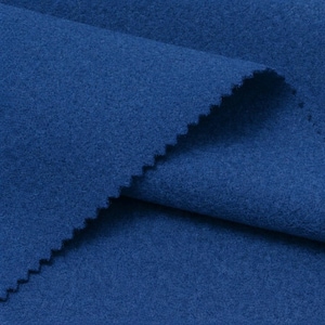 May include: A close-up of a piece of blue fabric with a soft, felt-like texture. The fabric is folded, showing a jagged edge. The colour is a deep, saturated blue, with subtle tonal variations across the surface.