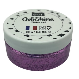 May include: A round jar of purple glitter gel labeled "OdiShine Glitter gel" with a French flag and washing instructions. The jar is 65 grams or 2.3 ounces.