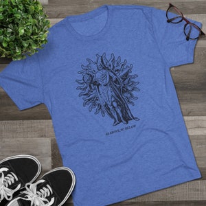 May include: A blue t-shirt with a black and white illustration of a person standing in a sun with the text "As Above, So Below".