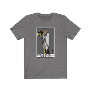 K&ouml;nnte beinhalten: Ein graues T-Shirt mit einer Schwarzwei&szlig;illustration einer Tarotkarte. Die Karte ist der Einsiedler und tr&auml;gt die Nummer IX und den aufgedruckten Schriftzug "DELEUZE".
