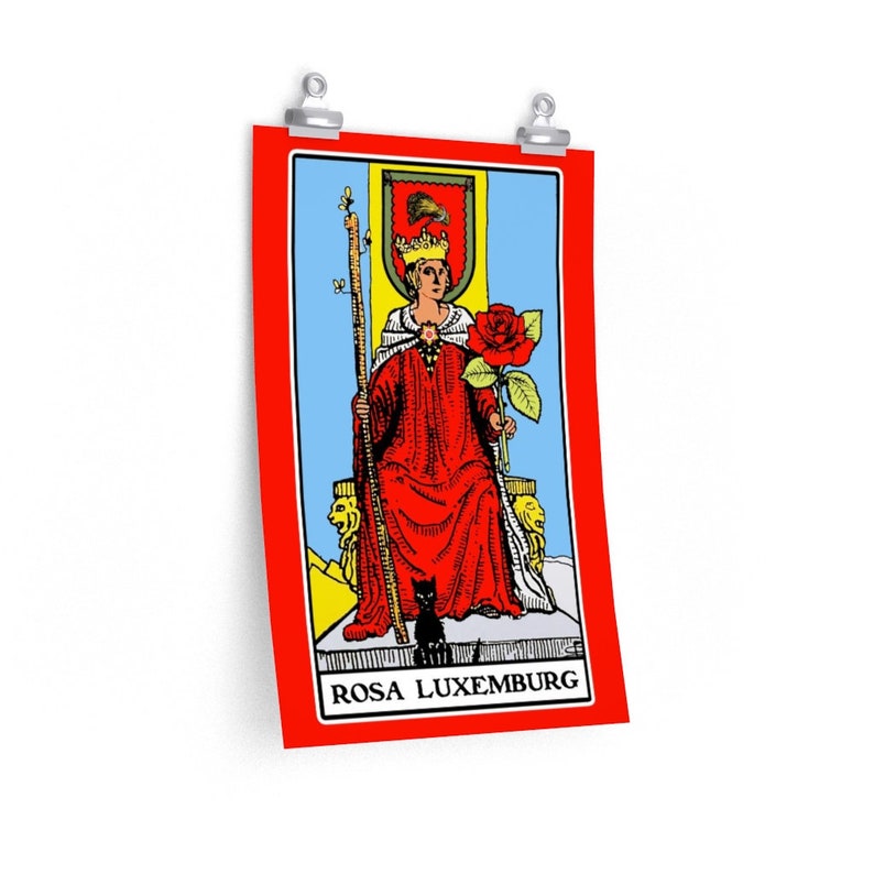 May include: A tarot card with a red background and a blue and white image of a woman sitting on a throne holding a rose. The card is titled "ROSA LUXEMBURG".