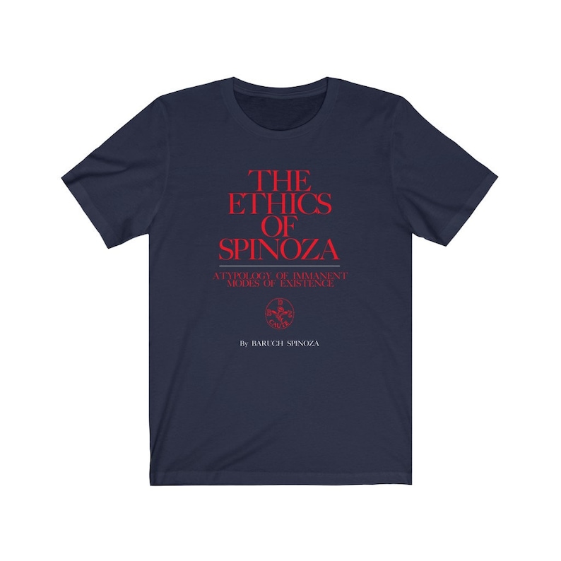 May include: A navy blue t-shirt with red text that reads "THE ETHICS OF SPINOZA" and "A TYPOLOGY OF IMMANENT MODES OF EXISTENCE" with a small red symbol and the text "By BARUCH SPINOZA" underneath.