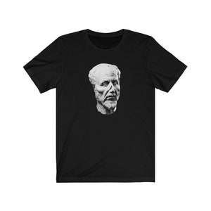 May include: A black t-shirt featuring a white image of a man's bust with a beard and a serious expression.