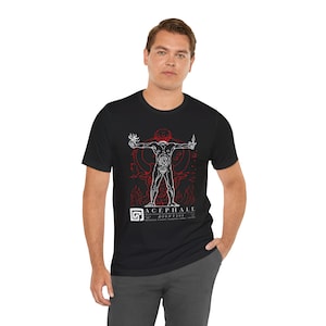 May include: Black t-shirt with a white graphic of a headless human figure with internal organs visible. The figure is surrounded by flames and the text "ACEPHALE DIONYSOS" is printed below.