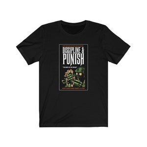 May include: Black t-shirt with a graphic of a book cover featuring a green and black monster holding a flower. The book title is "Discipline & Punish" with the subtitle "The Birth of the Prison". The text at the bottom of the cover reads "Enter a world where your virtue is a trap."