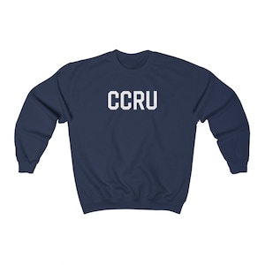 以下が含まれることがあります： 前面に白い文字で「CCRU」がプリントされたネイビーブルーのスウェットシャツです。