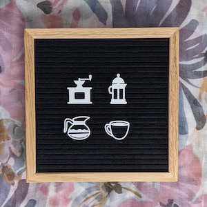 May include: A black letter board with white icons of a coffee grinder, a french press, a coffee pot, and a coffee cup.