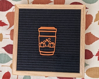 May include: A black felt letter board with a wooden frame. The board has a cutout of a coffee cup with a pumpkin spice design.