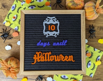 Może przedstawiać: Czarna tablica z literami w białej ramie, ozdobiona dekoracjami na Halloween. Na tablicy widnieje napis "10 dni do Halloween".