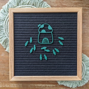 May include: A green felt letter board with a green mushroom house and several green mushroom shapes around it.