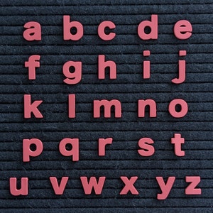 May include: A black felt letter board with the alphabet in red plastic letters. The letters are arranged in rows, starting with "a" and ending with "z".