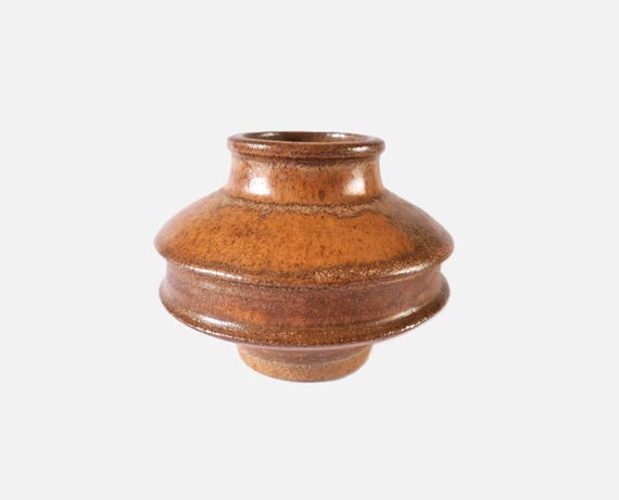 A signed vintage studio pottery hooped vase in warm brown — the kind of small art ceramic that looks like it was found at a gallery estate sale.