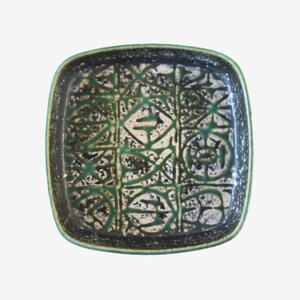 May include: A square ceramic dish featuring a dark green and black speckled glaze. The interior surface is decorated with a grid pattern containing abstract, hand-drawn geometric shapes and lines in a deep green tone against a light base.