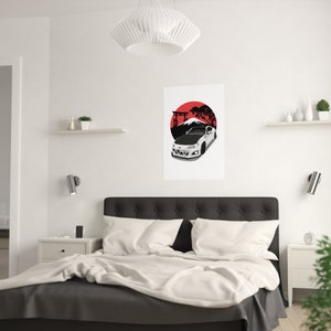 Modern bedroom with a minimalist design featuring a custom car art poster of a white sports car set against a red and black Japanese-inspired backdrop, mounted on a clean white wall above a cozy bed