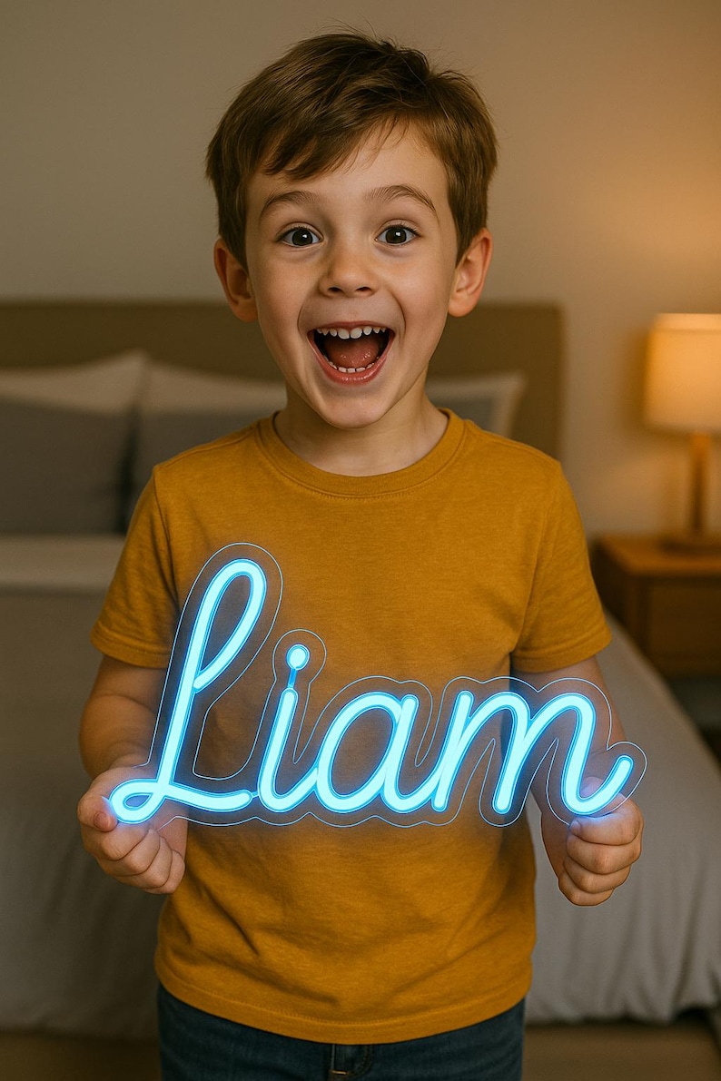 Puede incluir: Un letrero de ne&oacute;n azul con el nombre "Liam" en escritura cursiva. El letrero lo sostiene un ni&ntilde;o que lleva una camiseta de color amarillo mostaza y sonr&iacute;e. El fondo es un dormitorio.