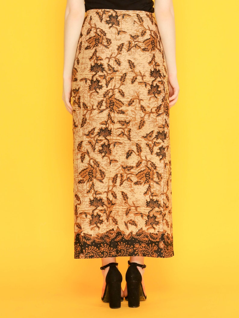 May include: A long brown skirt with a black floral pattern. The skirt has a fitted waist and a flowing hem. The skirt is made of a lightweight fabric and is perfect for warm weather.