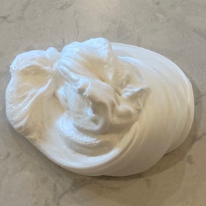 以下が含まれることがあります： 滑らかで光沢のある質感の白いスライム。スライムは大きく丸みを帯びた形をしており、非常に柔らかく、曲げやすいようです。