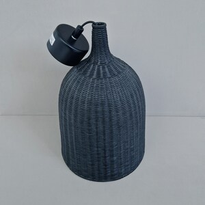 May include: Black woven pendant light fixture with a black cord and a black ceiling mount.
