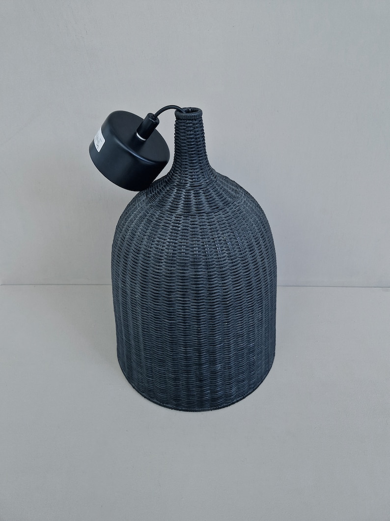 May include: Black woven pendant light fixture with a black cord and a black ceiling mount.