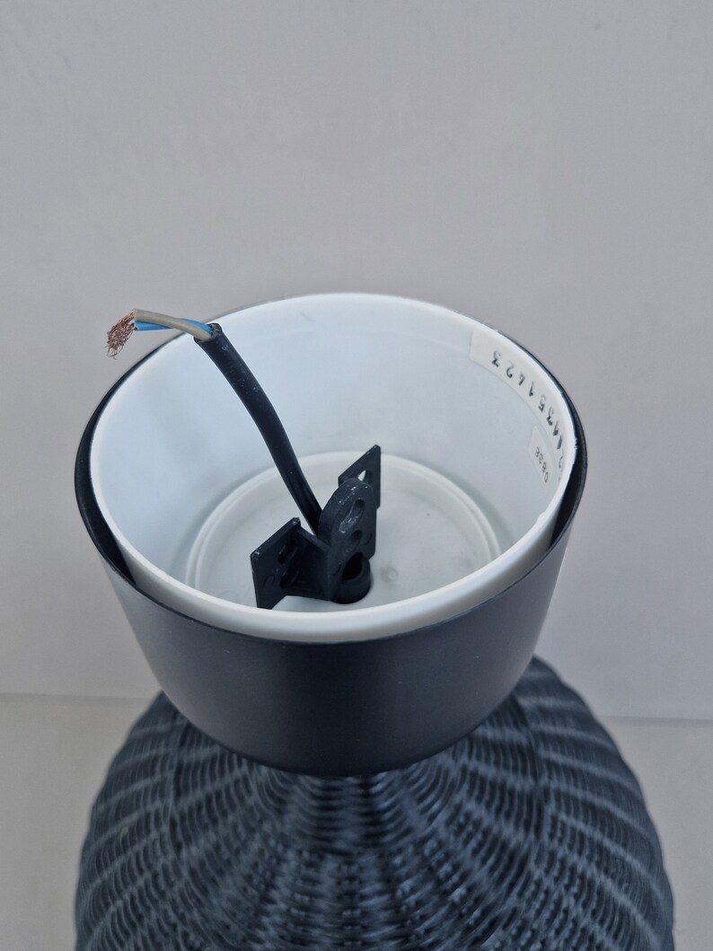 May include: Black wicker lampshade with a white interior and a black wire hanging from the top. The lampshade has a white sticker with the text "2671 3EW" on the side.