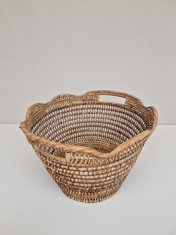 Vintage mand vervaardigd uit rattan met twee handvaten.