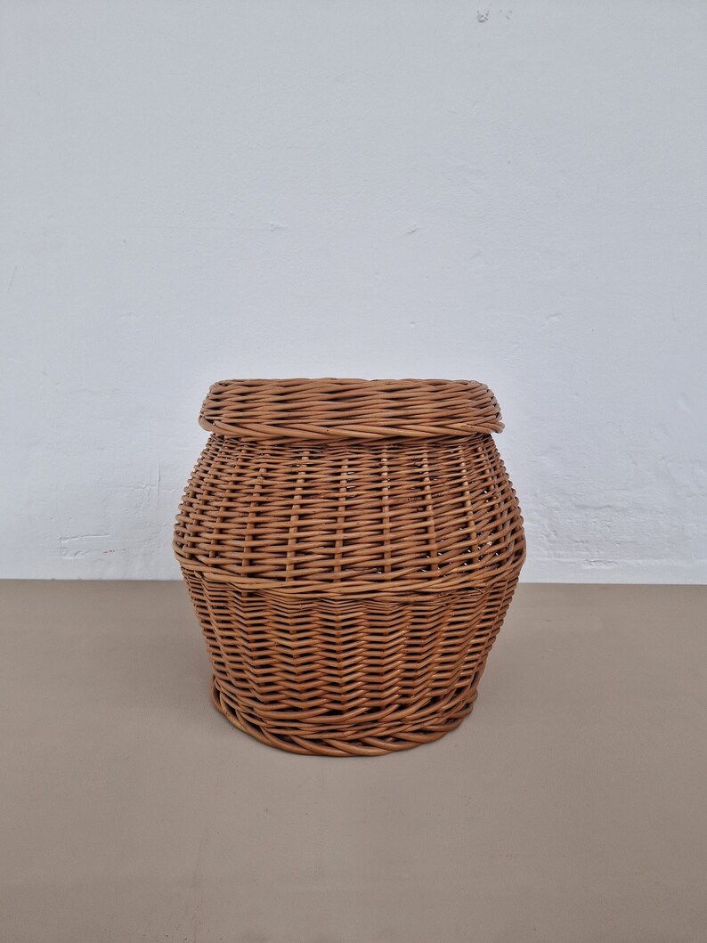 May include: A brown wicker basket with a rounded shape and a woven pattern.