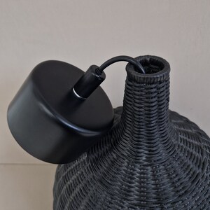 May include: Black woven pendant light fixture with a black metal ceiling canopy.