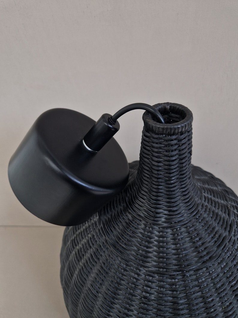 May include: Black woven pendant light fixture with a black metal ceiling canopy.