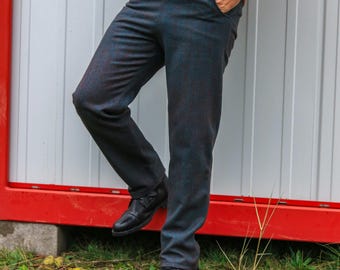 May include: A pair of dark blue plaid pants with a subtle sheen. The pants have a straight leg and are worn with black leather shoes.
