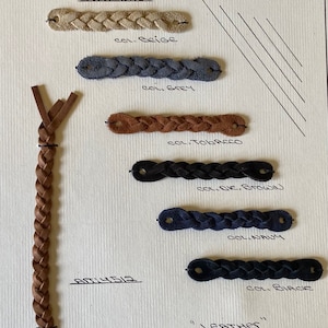 Könnte beinhalten: Darstellung von geflochtenen Leder-Locker-Loops in verschiedenen Farben, darunter Beige, Grau, Tabak, Braun, Marine und Schwarz. Das Bild zeigt auch ein längeres geflochtenes Lederstück und den Text "BRAIDED LOCKER LOOP" und "LEATHER".