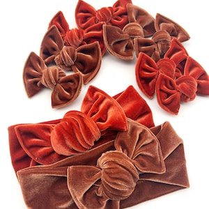 May include: A set of 10 velvet hair bows in two shades of brown. The bows are tied in a knot and have a soft, luxurious feel. The bows are perfect for adding a touch of elegance to any outfit.
