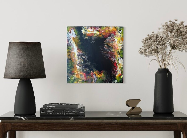 Pode incluir: Pintura abstrata com cores que giram em amarelo, laranja, vermelho, verde e branco em torno de um centro preto.