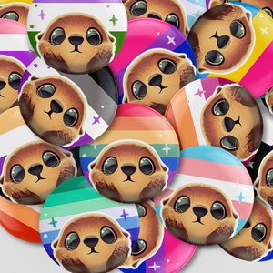 May include: A collection of colorful round buttons featuring a cartoon otter with different pride flag designs. The buttons are perfect for showing your pride and support for the LGBTQ+ community.