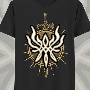 May include: Black t-shirt with a gold and white graphic of a sword and wings. The graphic is surrounded by a circle with a sunburst design.