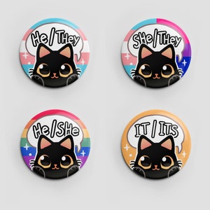 Puede incluir: Cuatro botones redondos con ilustraciones de gatos negros y diferentes combinaciones de pronombres. Los botones presentan un dise&ntilde;o de bandera arco&iacute;ris, transg&eacute;nero, bisexual y de g&eacute;nero neutro.