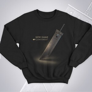 May include: Black sweatshirt with a gold graphic of a sword and the text "NEW GAME CONTINUE?"