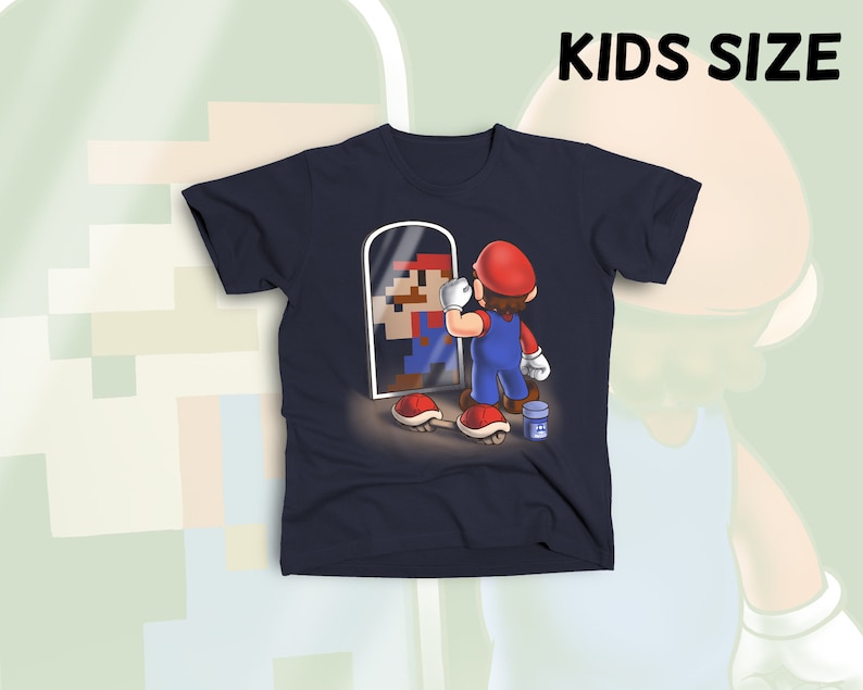 May include: A navy blue t-shirt with a graphic of a pixelated Super Mario character looking in a mirror at a realistic Super Mario character. The text "KIDS SIZE" is in white letters at the top of the image.