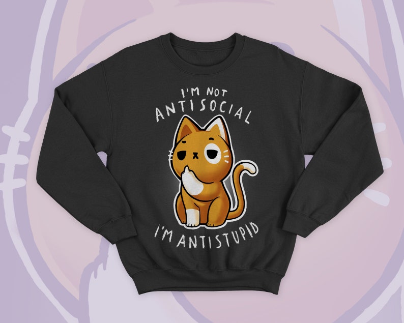 May include: Black sweatshirt featuring a cartoon cat with a sassy expression. The cat is orange and white, with the text "I'M NOT ANTISOCIAL I'M ANTISTUPID" in white above and below the cat. The sweatshirt has long sleeves and a crew neck.