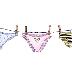 May include: Three pairs of underwear hang on a washing line, held by wooden pegs. The underwear includes a pair with blue polka dots, a pink pair with a heart, and a striped pair in black and tan.