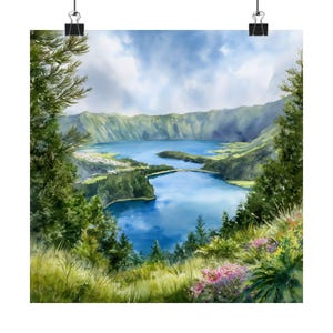 May include: A watercolour print depicting a tranquil landscape with a blue lake, green hills, and verdant vegetation. The artwork showcases a peaceful scene under a cloudy sky, creating a naturalistic aesthetic. The print is held by two black binder clips.