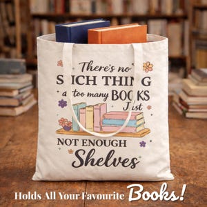 Puede incluir: Una bolsa de lona blanca con el texto "There's no such thing as too many books, just not enough shelves." La bolsa contiene dos libros, uno azul y otro naranja. La parte inferior de la bolsa dice "Holds All Your Favourite Books!"