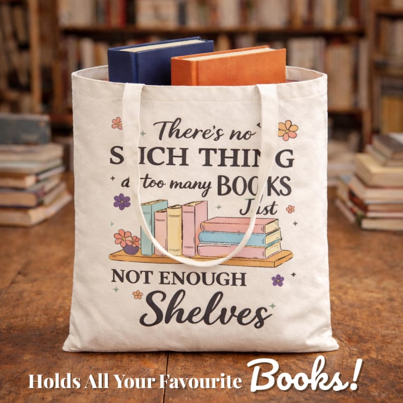 Puede incluir: Una bolsa de lona blanca con el texto "There's no such thing as too many books, just not enough shelves." La bolsa contiene dos libros, uno azul y otro naranja. La parte inferior de la bolsa dice "Holds All Your Favourite Books!"