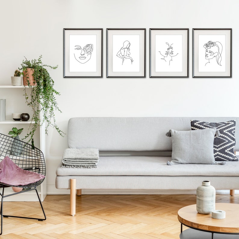 Puede incluir: Cuatro impresiones enmarcadas en blanco y negro de arte lineal de rostros abstractos cuelgan sobre un sof&aacute; gris. El arte presenta dibujos lineales minimalistas de rostros con elementos florales y abstractos. La habitaci&oacute;n tiene una est&eacute;tica moderna y minimalista.